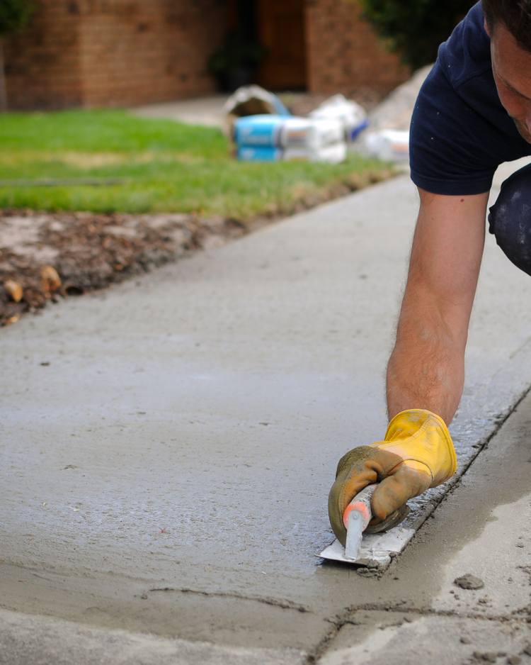 Man smoothing concrete on a walkway